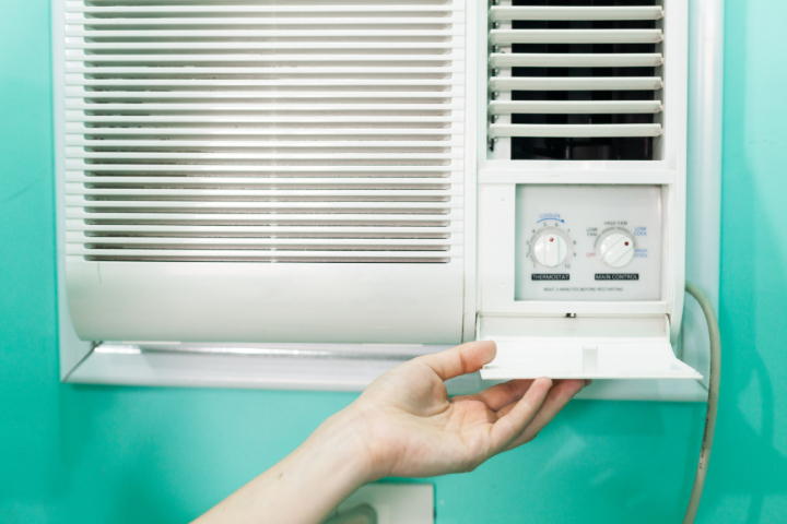woman adjusting a thermostat