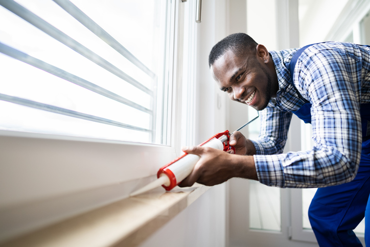 Man Caulking Window